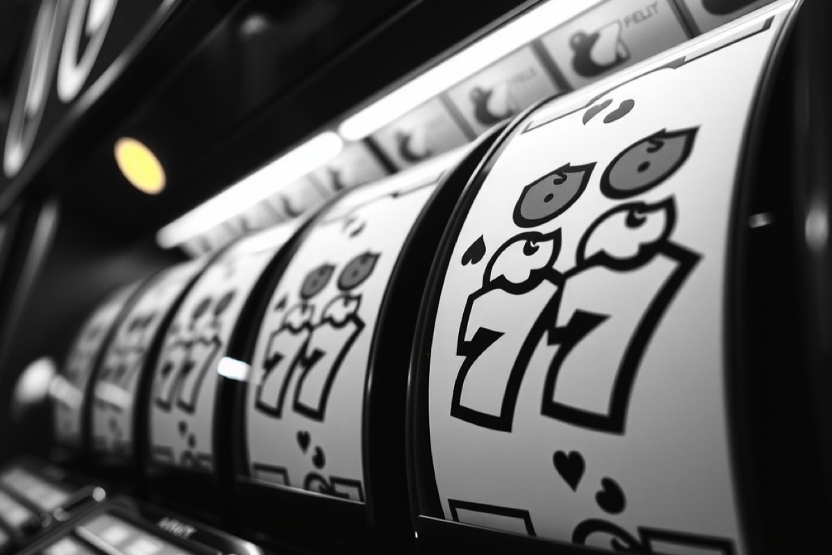 Slot machine reels showing cherries and bells behind curved glass